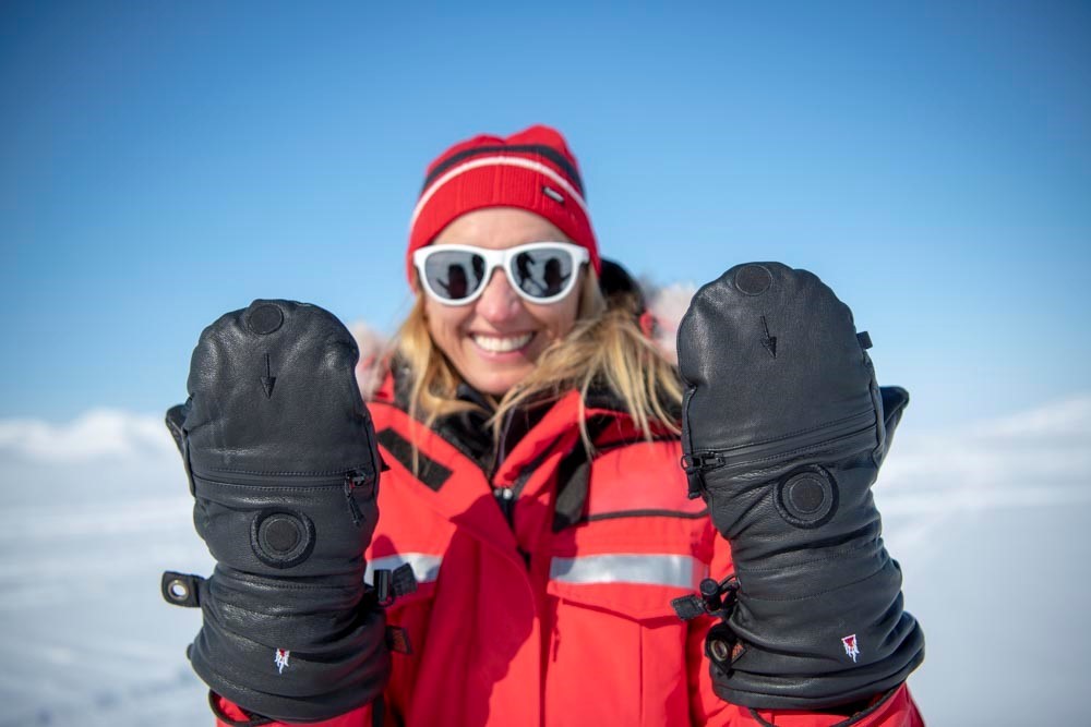 Woman with thick expedition mittens in the high mountains