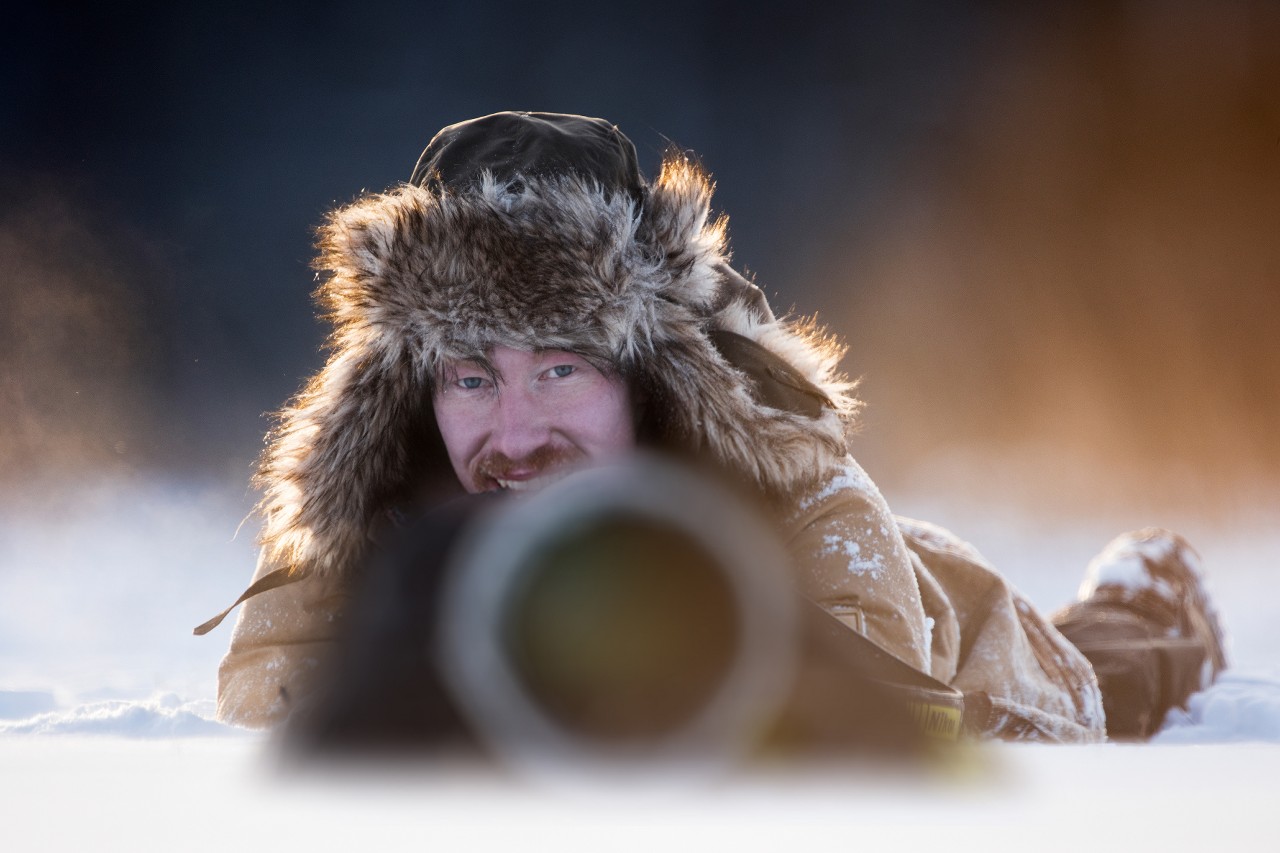 Der deutsche Naturfotograf Florian Smit mit einem großen Teleobjektiv