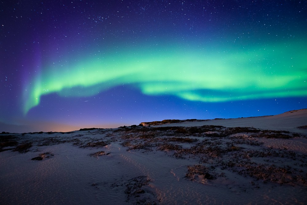 Green Northern Lights on dark-blue night sky