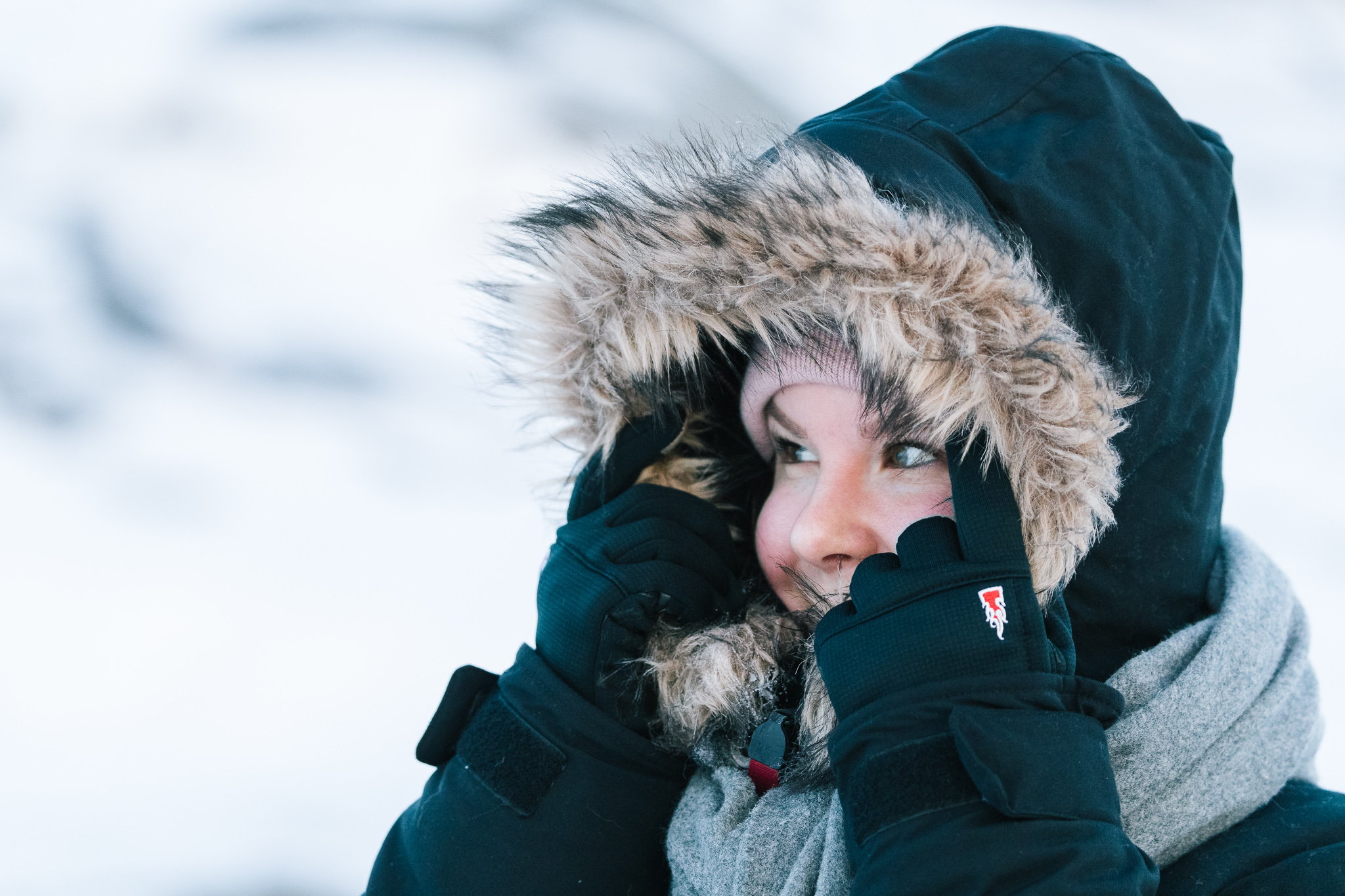 woman holding her hood with gloves