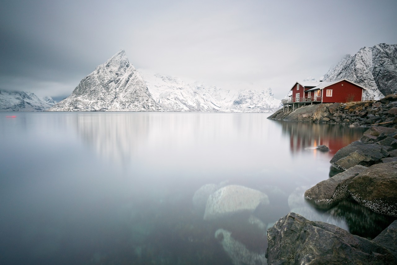 Langzeitbelichtung von einem roten Haus in Norwegen mit Meer