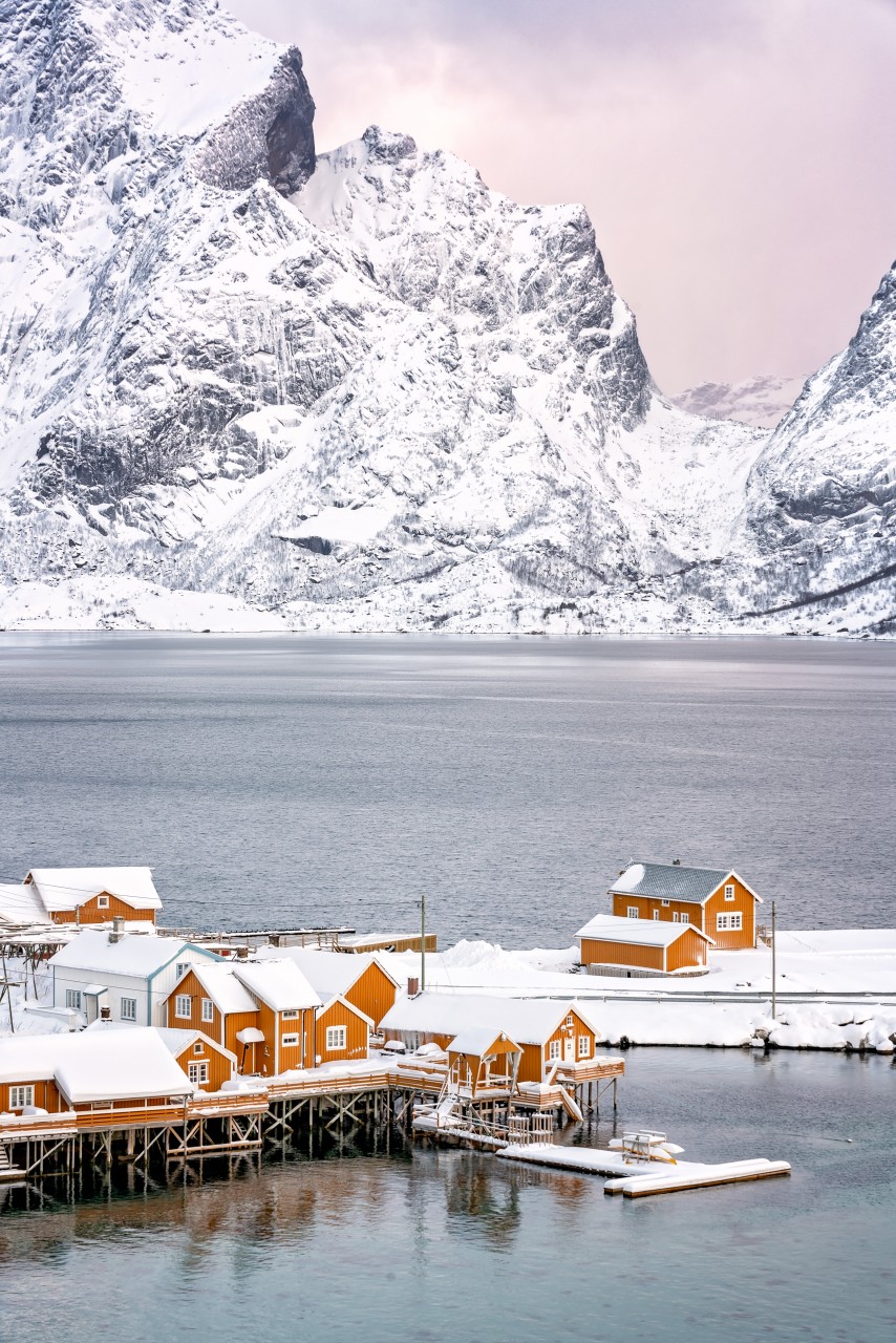 Ein Dorf auf den Lofoten mit orangenen Häusern im Winter