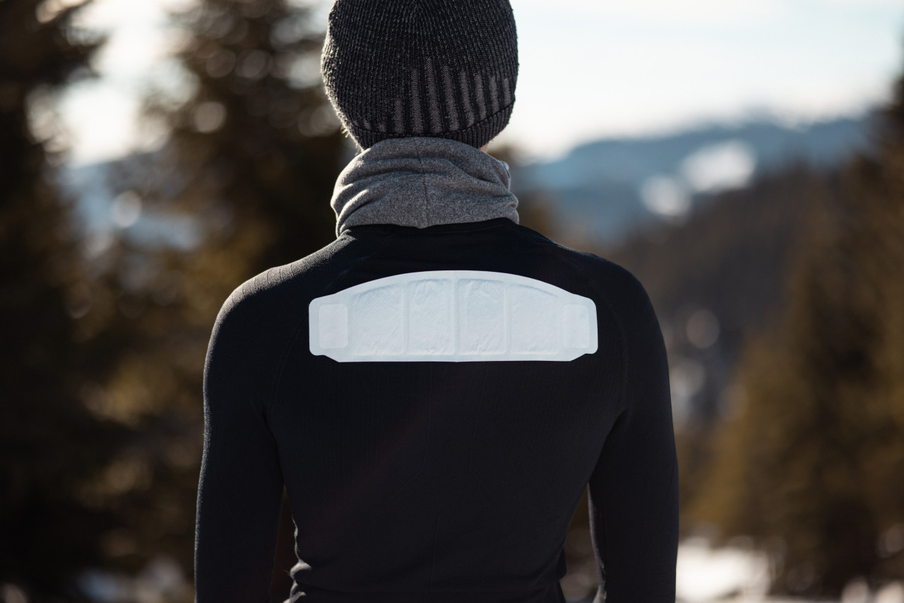 Man wears air activated warmer for shoulders on upper back