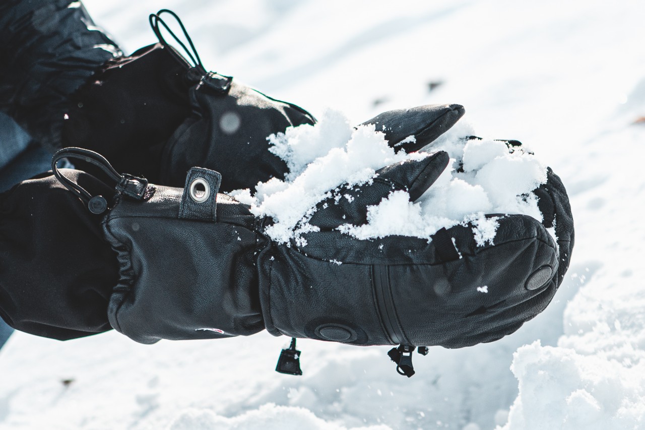 Nahaufnahme eines Leder-Fäustlings im Schnee