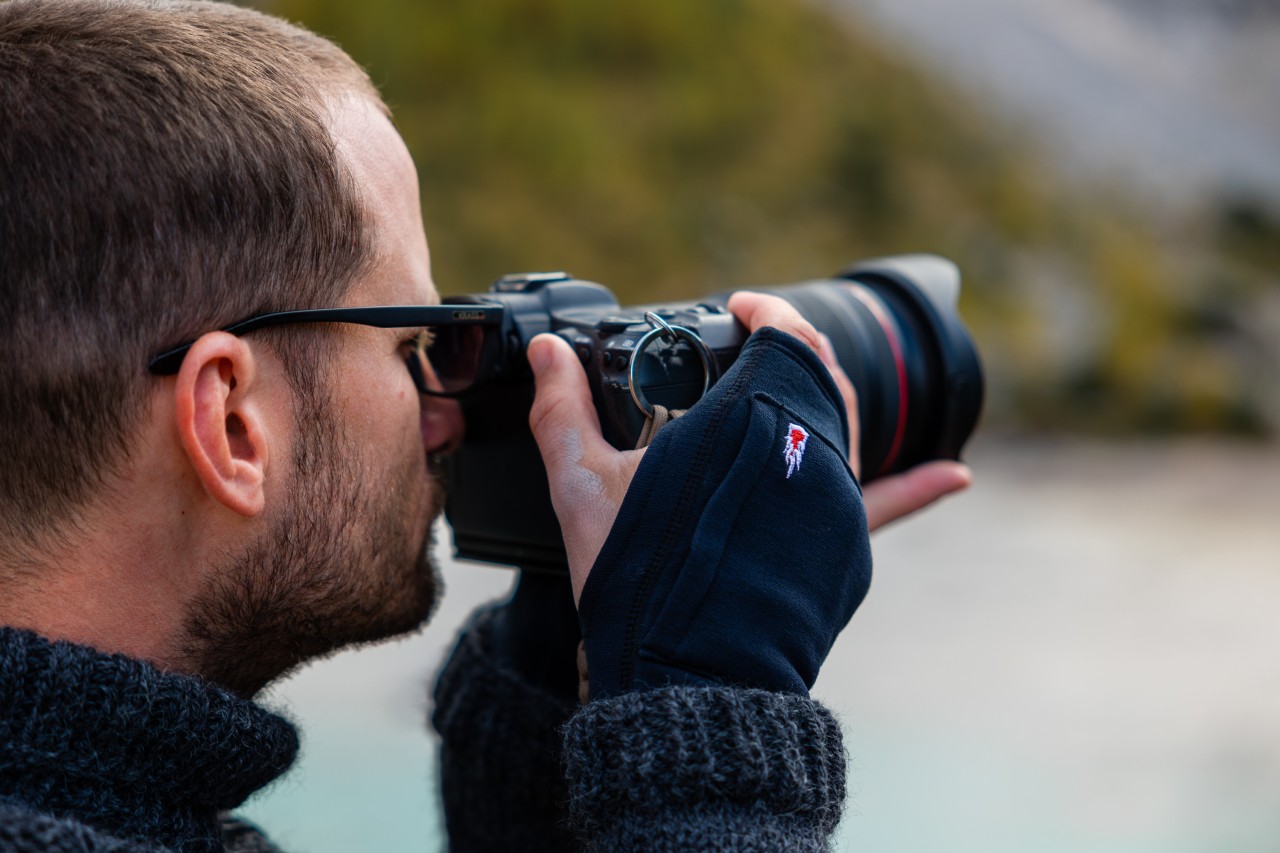 Man with camera in hand with fingerless gloves