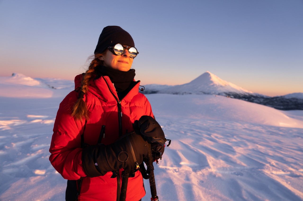 Mujer en las montañas nevadas con manoplas