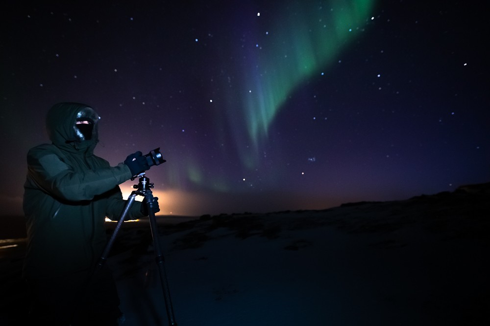 Aurora boreale - fotografo con treppiede e guanti da fotografia