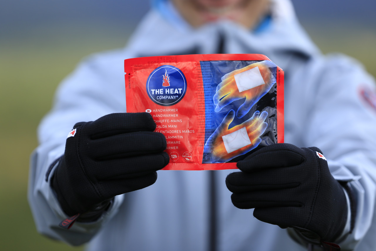 Woman shows hand warmer package to camera