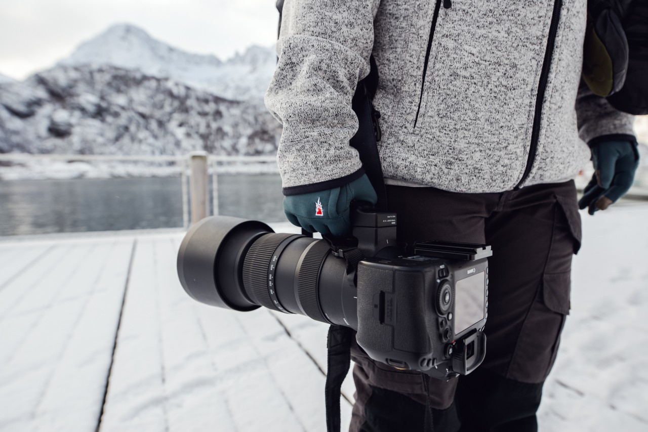 Gros plan d'une photographe avec un téléobjectif en hiver
