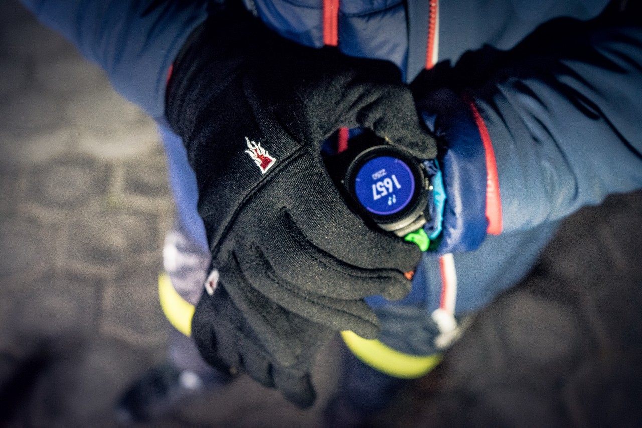 Person accesses his sports watch with finger gloves