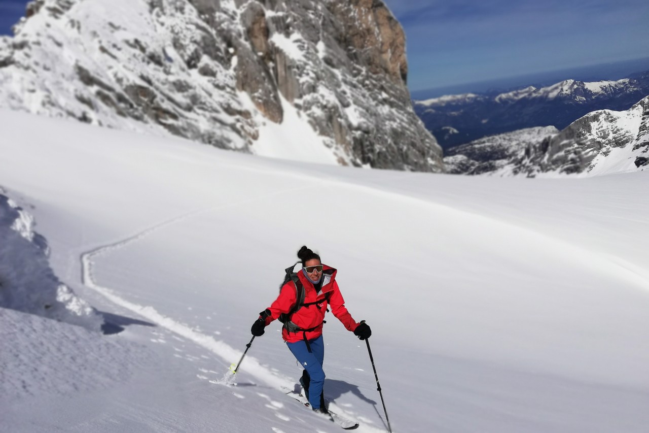 Donna che fa un tour sugli sci nelle montagne innevate