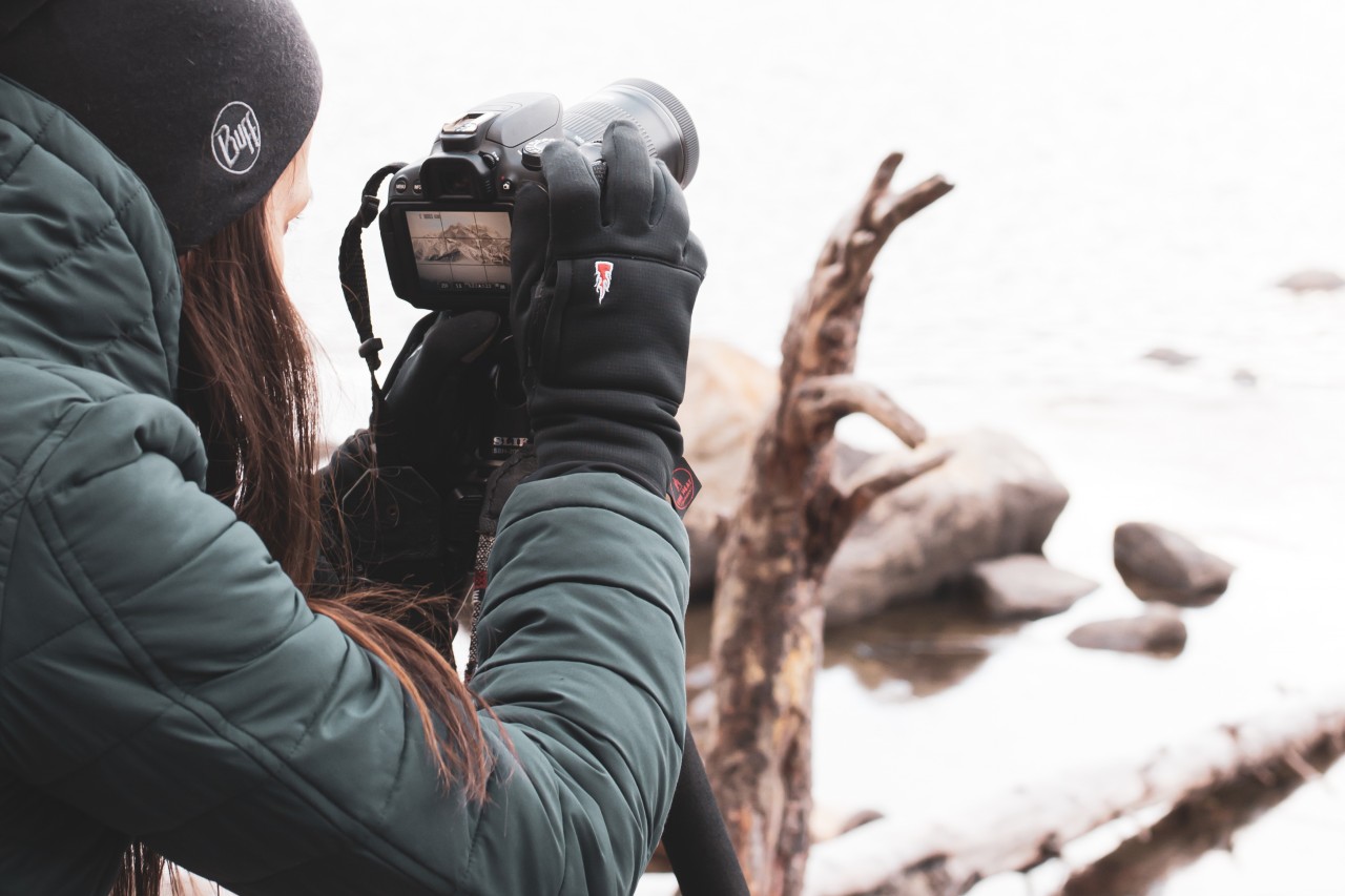 vrouw maakt foto's in de winter met handschoenen aan