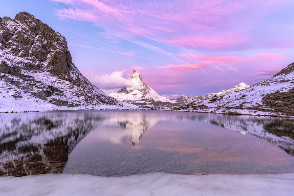 Rosa Wolken rund ums Matterhorn mit Spiegelgung am Riffelsee