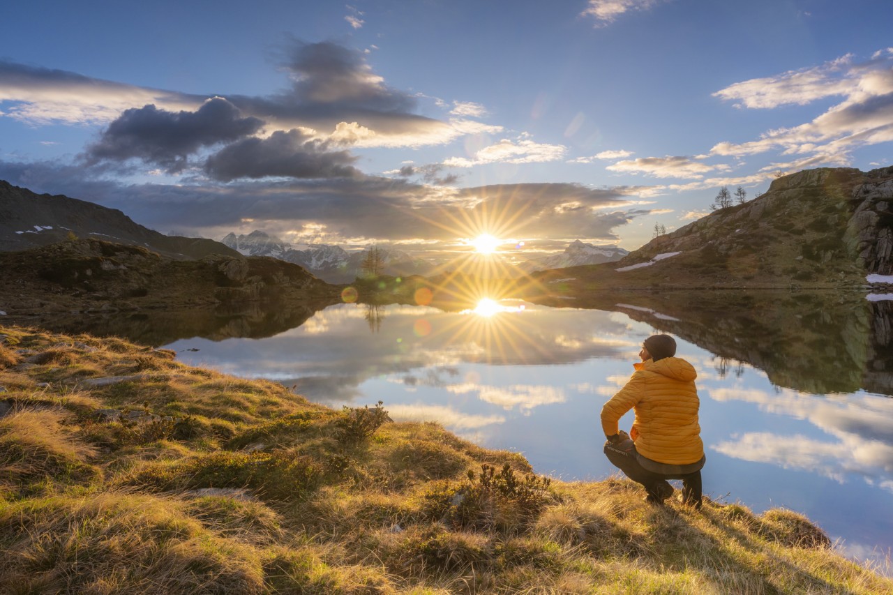 Sonnenaufgang am Alpensee Lago di Zana mit Roberto Moiola knieend im Vordergrund