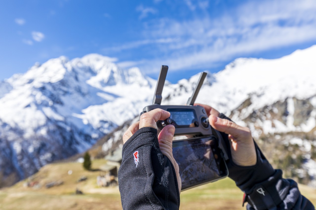 Man bedient drone met vingerloze handschoenen