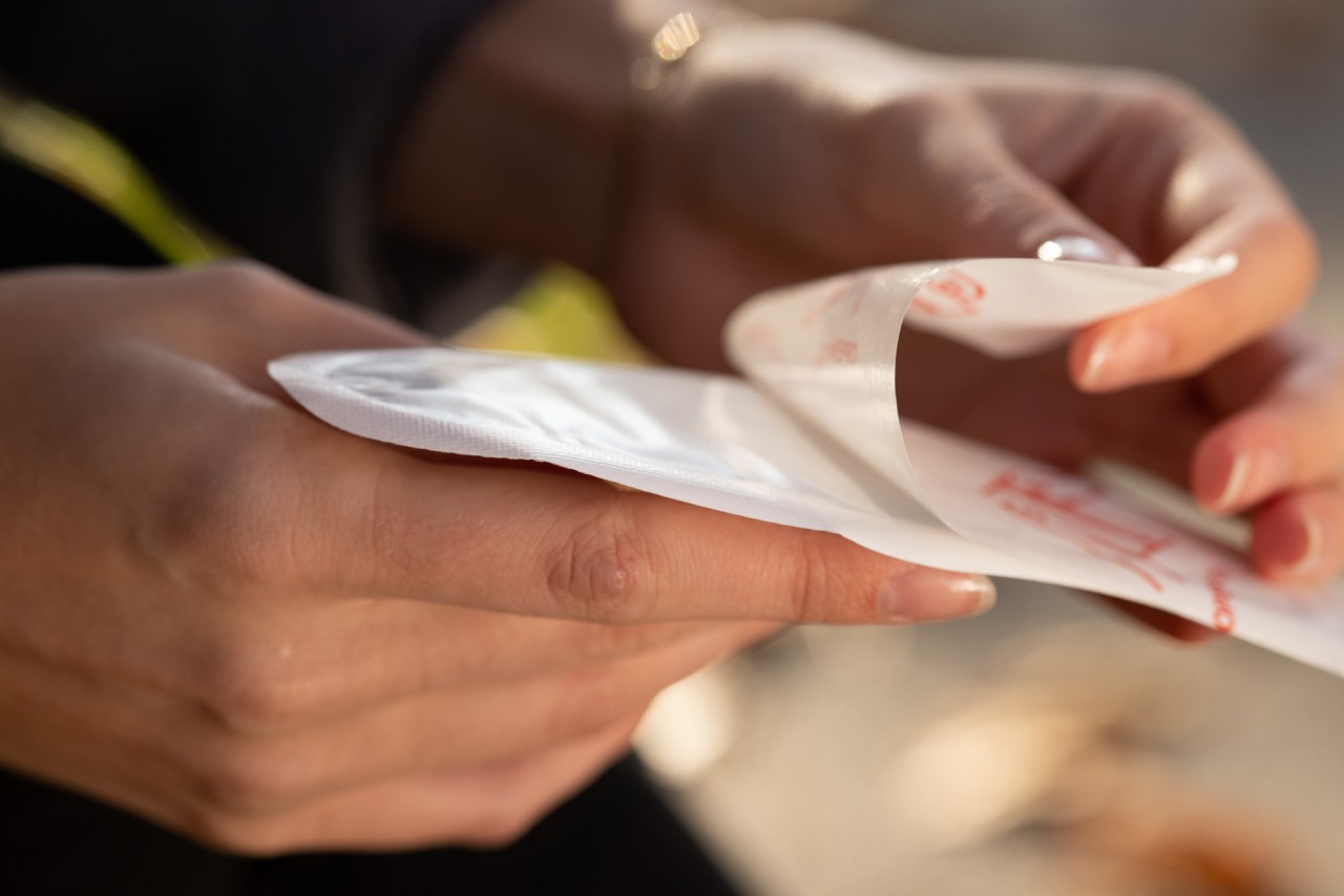 Person pulls a protective film from an insole warmer with adhesive surface