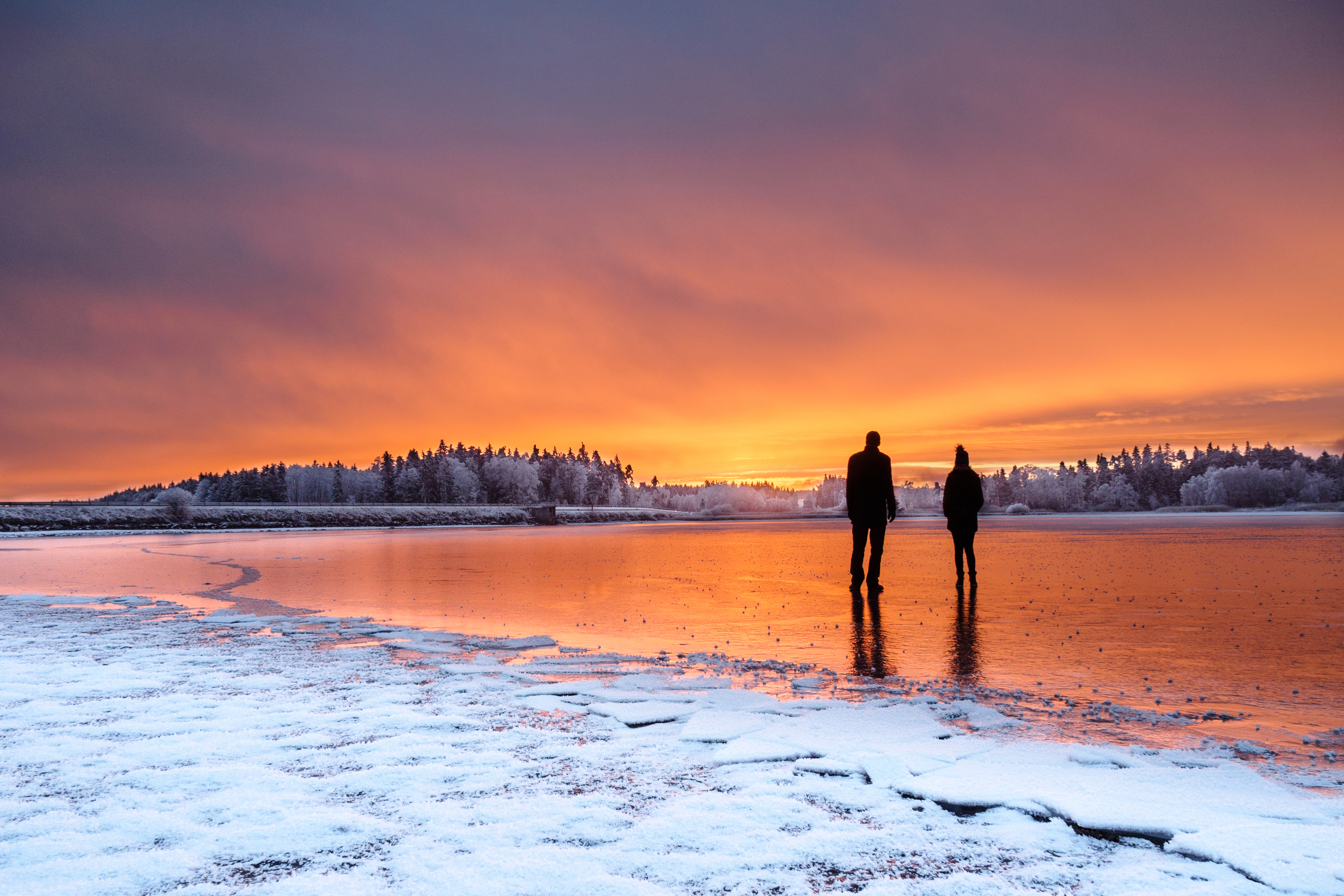 Silhouette of a couple against a winter sunset, creating a strong focal point.